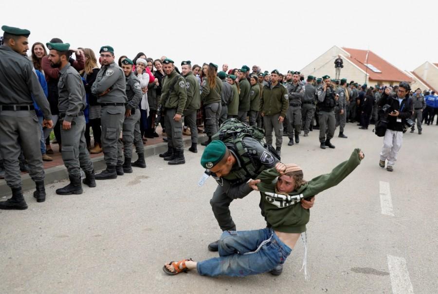 An Israeli border policeman removes a pro-settlement activist during an operation by Israeli forces to evict residents from several homes in the Israeli settlement of Ofra, in the occupied West Bank February 28, 2017. Israel,Israeli police,Palestinian land,West Bank,Ofra