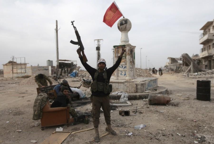 A rebel fighter reacts carrying his weapon near damaged buildings in the northern Syrian town of al-Bab, Syria February 28, 2017. Syria,Al-Bab after Islamic State,Islamic State,Syrian city,Islamic State militants,Turkish-backed rebels