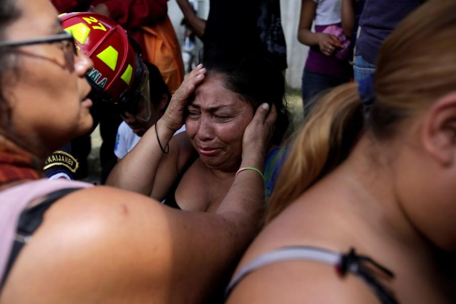 Family members react as they wait for news of their loved ones after a fire broke at the Virgen de Asuncion home in San Jose Pinula, on the outskirts of Guatemala City, Guatemala. The blaze that has killed at least 37 and maimed others at an overcrowded Guatemalan shelter for abused teens broke out in a tiny room they were locked in to control them after a riot at the center, authorities and witnesses said. Mourning girls,Guatemala mourns,death under lock,Madelin Patricia Hernandez,Guatemala City