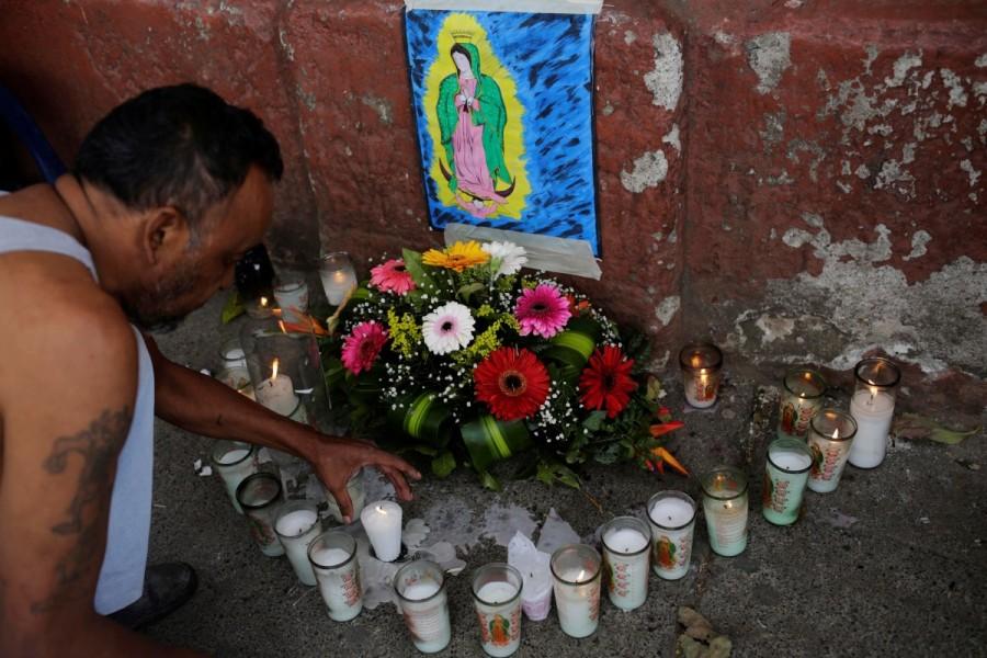 A family member places a candle outside the morgue where the bodies of victims are located. The Virgen de la Asuncion center has a history of abuse accusations documented by Guatemalan media. Over the last three years more than 250 of its residents have fled, newspaper reports said. Mourning girls,Guatemala mourns,death under lock,Madelin Patricia Hernandez,Guatemala City