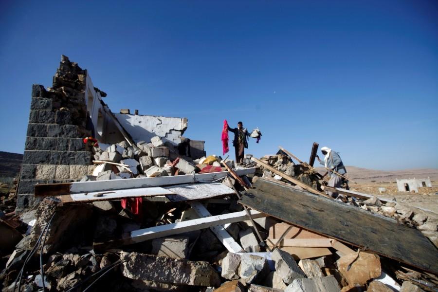 People inspect damages at the site of a Saudi-led air strike which struck a house where mourners had gathered for a funeral north of Yemen's capital Sanaa. Saudi-led Arab coalition,Saudi-led Arab,war in Yemen,Saudi Arabia's war in Yemen,Yemen,Yemen war,Iran-allied Houthi movement,Houthi movement
