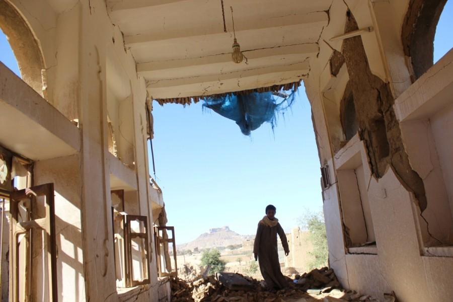 A boy walks inside a house destroyed by a recent Saudi-led air strike in the northwestern city of Saada, Yemen. Saudi-led Arab coalition,Saudi-led Arab,war in Yemen,Saudi Arabia's war in Yemen,Yemen,Yemen war,Iran-allied Houthi movement,Houthi movement