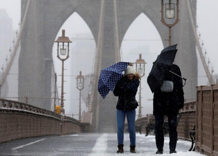People fight the wind and snow as they walk across the Brooklyn Bridge in New York City. Blizzard blankets,Snow blankets,Blizzard blankets the Northeast,northeastern United States,United States,Snow at United States