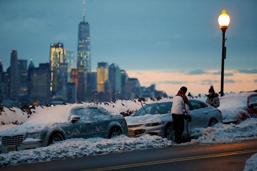 Residents clear their cars and street of snow in Weehawken, New Jersey, as the One World Trade Center and lower Manhattan are seen after a snowstorm in New York. Blizzard blankets,Snow blankets,Blizzard blankets the Northeast,northeastern United States,United States,Snow at United States