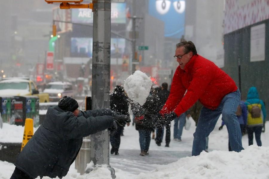 A man and child take part in a snowball fight in Times Square during a snowstorm, New York. Blizzard blankets,Snow blankets,Blizzard blankets the Northeast,northeastern United States,United States,Snow at United States