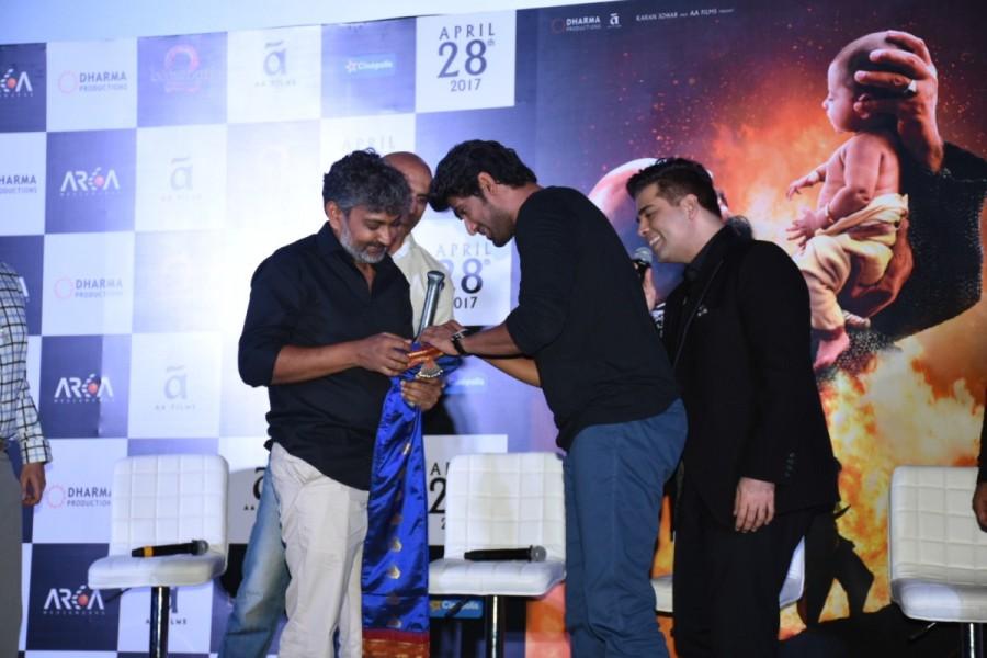 Two years later, the producers reunited along with director SS Rajamouli, lead actor Prabhas and antagonist Rana Daggubati in addition to Anil Thadani, introducing the audience to yet another magnum opus experience in the form of the trailer of Baahubali : The Conclusion. The trailer of Baahubali : The Conclusion was met with a thunderous response upon its showcasing, leaving the Baahubali team overwhelmed. SS Rajamouli,Kattapa,Kattapa sword,Karan Johar,Baahubali,Baahubali 2,Baahubali 2 trailer launch,Baahubali 2 trailer,Baahubali 2 trailer launch pics,Baahubali 2 trailer launch images,Baahubali 2 trailer launch photos,Baahubali 2 trailer launch stills,Baahu