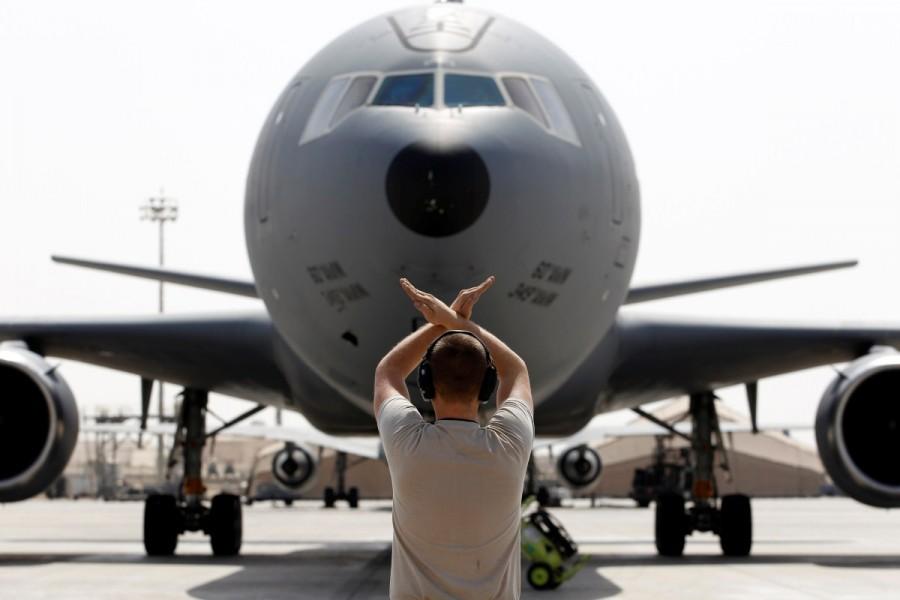 A U.S. Air Force ground director guides the KC-10 Extender upon its arrival after providing mid-air refueling support at an Air Force Base in Arabian Gulf. Americans fight Islamic State,Americans fight,Islamic State,Iraq and Syria,Iraq,Syria,U.S. forces