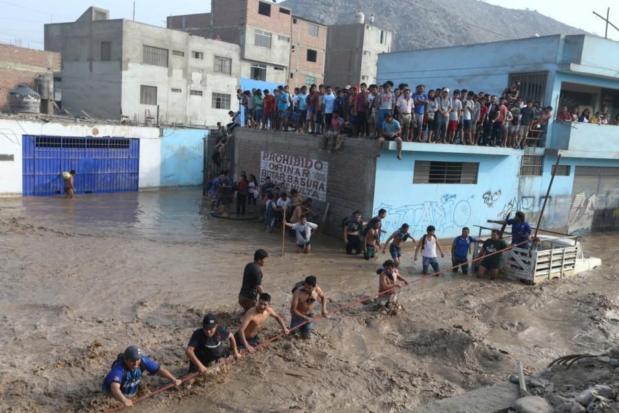 People trapped on a roof get rescued by the police after a massive landslide and flood in the Huachipa district of Lima, Peru March 17, 2017. Floods,landslides,Floods in Peru,landslides in Peru,Peru floods
