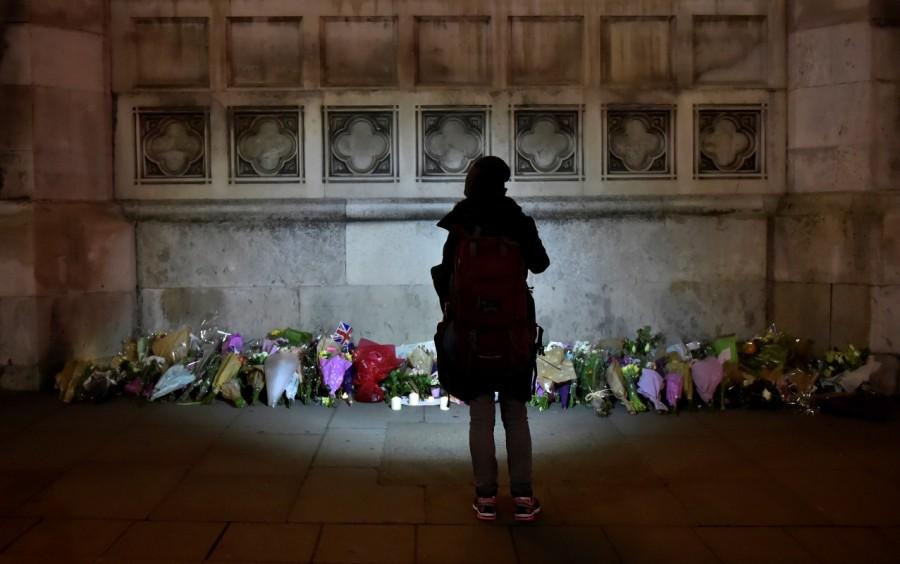 A woman looks at floral tributes laid in Westminster the day after an attack in London. Parliament,parliament attact,Mourning for London,London attack victims,London victims,Mourning for London attack victims