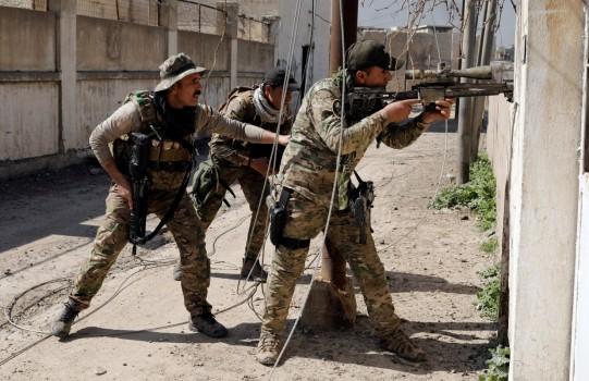 An Iraqi rapid response sniper aims his weapon toward a suspected Islamic State sniper's position in western Mosul.