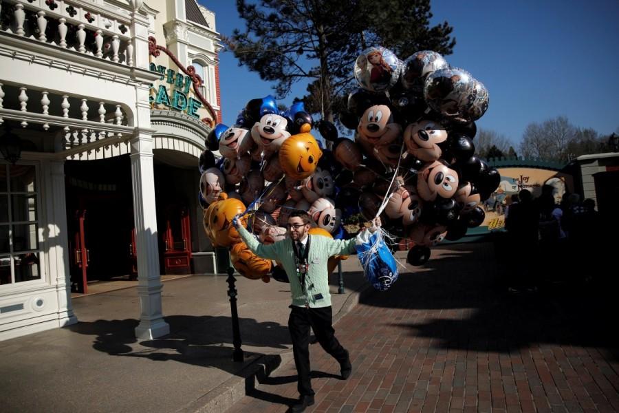 A Disneyland Paris employee sells Mickey and Minnie Mouse balloons along Main Street. Disneyland Paris,Disneyland,Disney Stars,Disneyland Paris turns 25,25th anniversary of Disneyland Paris,Disneyland Paris 25