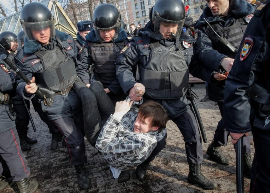 Law enforcement officers detain an opposition supporter during a rally in Moscow. Russian police,police detain protesters,Russian protesters,Alexei Navalny,protesters across Russia,opposition leader Alexei Navalny,demonstrate against corruption,corruption