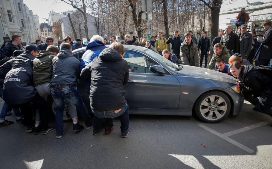 Opposition supporters move a car to block the road to prevent the van transporting detained anti-corruption campaigner and opposition figure Alexei Navalny during a rally in Moscow. Russian police,police detain protesters,Russian protesters,Alexei Navalny,protesters across Russia,opposition leader Alexei Navalny,demonstrate against corruption,corruption