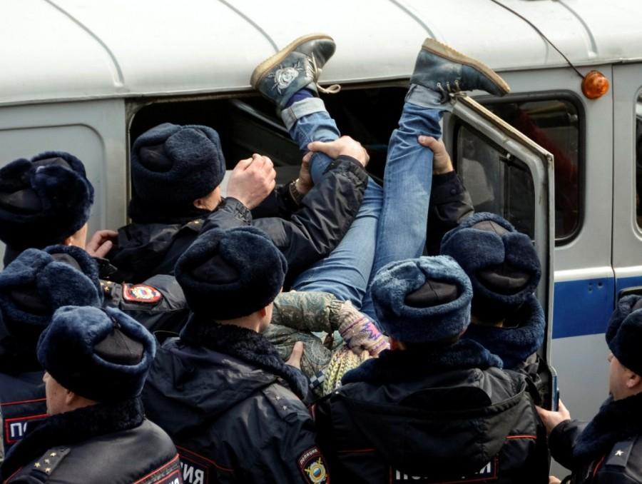 Police officers detain an opposition supporter during a rally in Vladivostok. Russian police,police detain protesters,Russian protesters,Alexei Navalny,protesters across Russia,opposition leader Alexei Navalny,demonstrate against corruption,corruption