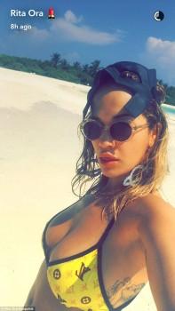 Hollywood actress Rita Ora flaunts ample assets in tiny yellow bikini.