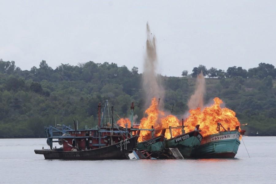 Malaysian and Vietnamese fishing boats are destroyed for illegal fishing by the Ministry of Maritime Affairs and Fisheries, police and navy, in Batam, Riau Islands, Indonesia. Indonesia,illegal fishing boats,fishing boats,destroys illegal fishing boats,Indonesian navy