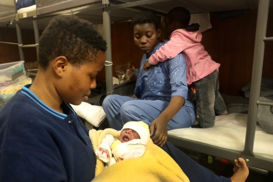 A Nigerian woman holds a baby girl as the baby's mother, Mariam, rests next to her other child, two-year old Benjamin aboard the former fishing trawler Golfo Azzurro about thirty-two hours. The baby's mother, a 29-year old Nigerian woman, and her husband, a 34-year old worker from Ghana, were also rescued. They had lived in Libya for over two years and decided to leave for Europe after they had the baby. "We want to go to France or Germany, there is a future for our family there," Richard Ohene, the father, told Reuters. Mediterranean,Mediterranean sea,480 migrants rescued,Baby migrants,migrants