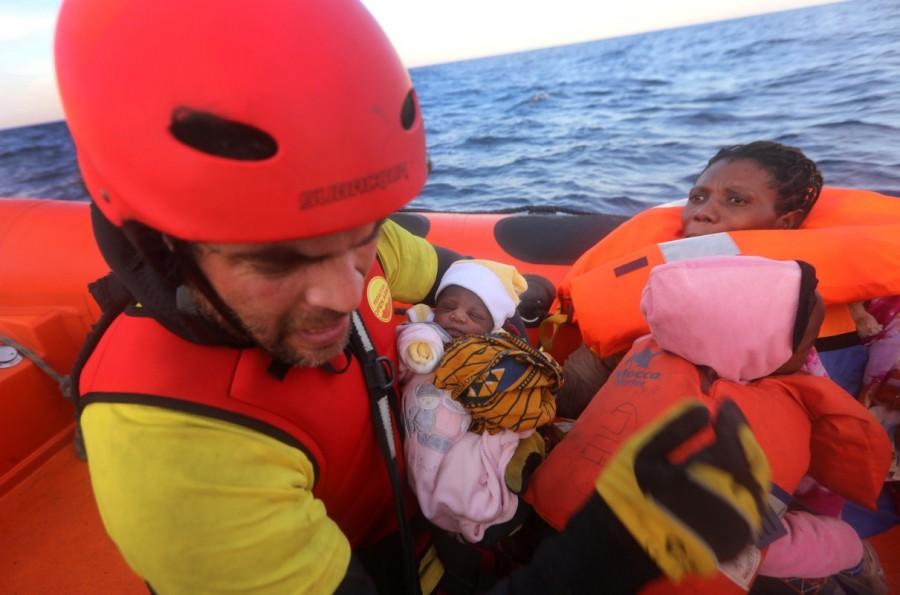 Spanish rescuer, Asier Renedo, 37, hands over a four-day-old baby girl to a woman into a RHIB, during a search and rescue operation. The operation was carried out by Spanish NGO Proactiva Open arms and lasted three hours. Migrants were transferred into the former fishing trawler Golfo Azzurro, expected to reach the Sicilian port town of Augusta the following afternoon. Mediterranean,Mediterranean sea,480 migrants rescued,Baby migrants,migrants