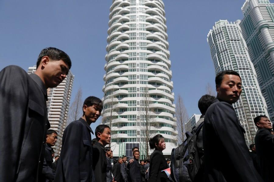 People walk between buildings after the opening ceremony of a newly constructed residential complex in Ryomyong street. North Korea,Pyongyang,Postcards from Pyongyang,Kim Il-sung,father Kim Il-sung