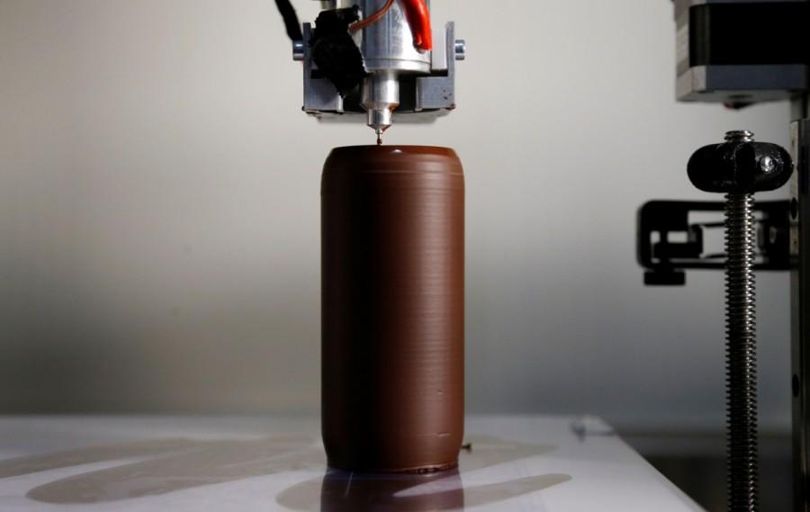 A specialized 3D printing machine applies melted chocolate to shape a chocolate beer bottle at Belgian chocolate company Miam Factory in Gembloux. Chocolate printed in 3D,Chocolate 3D,printed in 3D,Beer bottles,Belgian chocolate company,Miam Factory