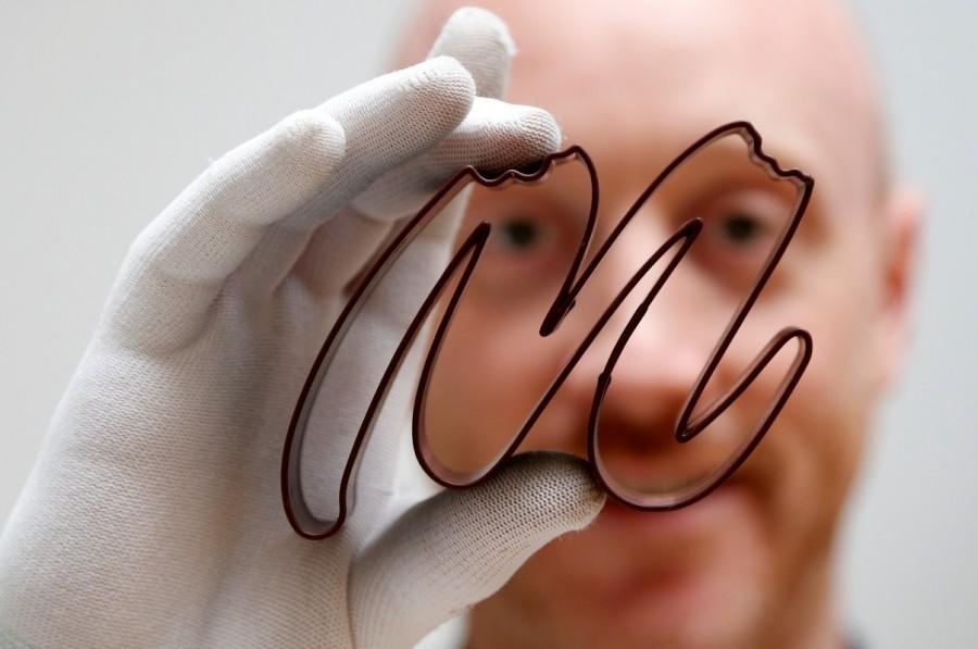 Gaetan Richard poses with the logo of the Miam Factory 3D printing chocolate company after being printed by a specialized 3D machine in Gembloux. Chocolate printed in 3D,Chocolate 3D,printed in 3D,Beer bottles,Belgian chocolate company,Miam Factory