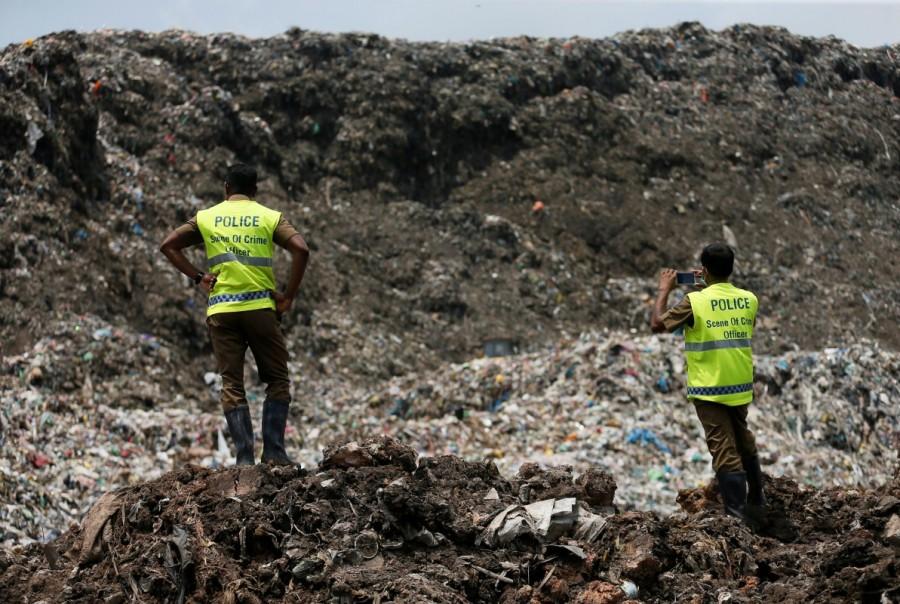 Sri Lankan crime police officers take pictures of the garbage dump during a rescue mission after a garbage dump collapsed and buried dozens of houses in Colombo, Sri Lanka April 16, 2017. Deadly garbage,Deadly garbage landslide in Sri Lanka,Deadly garbage in Sri Lanka,Sri Lanka,giant rubbish dump,rubbish dump,Colombo