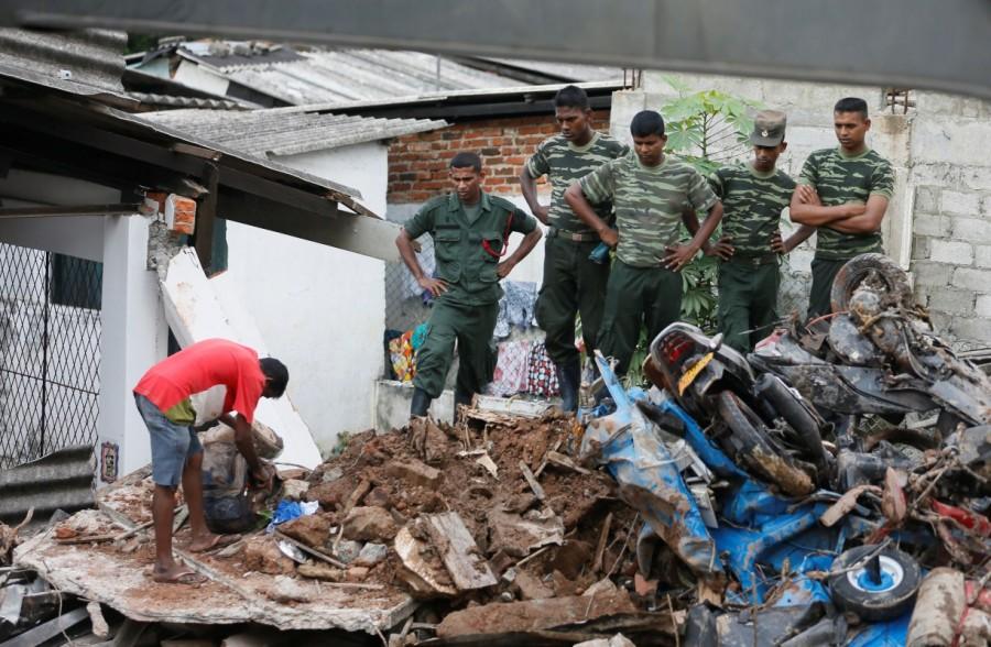 A man opens a bag next to military officers during a rescue mission after a garbage dump collapsed and buried dozens of houses in Colombo, Sri Lanka April 15, 2017. Deadly garbage,Deadly garbage landslide in Sri Lanka,Deadly garbage in Sri Lanka,Sri Lanka,giant rubbish dump,rubbish dump,Colombo