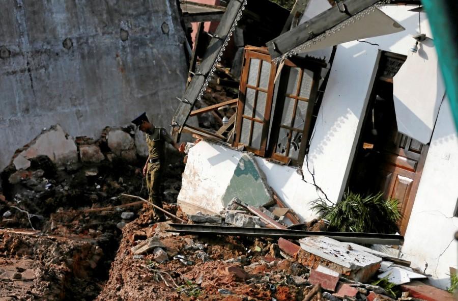 A police officer inspects a damaged house for victims during a rescue mission after a garbage dump collapsed and buried dozens of houses in Colombo, Sri Lanka April 15, 2017. Deadly garbage,Deadly garbage landslide in Sri Lanka,Deadly garbage in Sri Lanka,Sri Lanka,giant rubbish dump,rubbish dump,Colombo