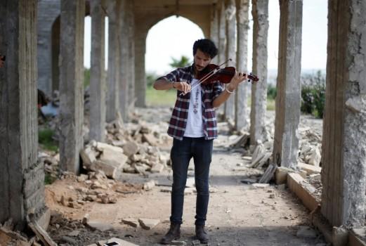 Ameen Mukdad, a violinist from Mosul who lived under ISIS's rule for two and a half years where they destroyed his musical instruments, performs at Nabi Yunus shrine in eastern Mosul, Iraq, April 19, 2017.