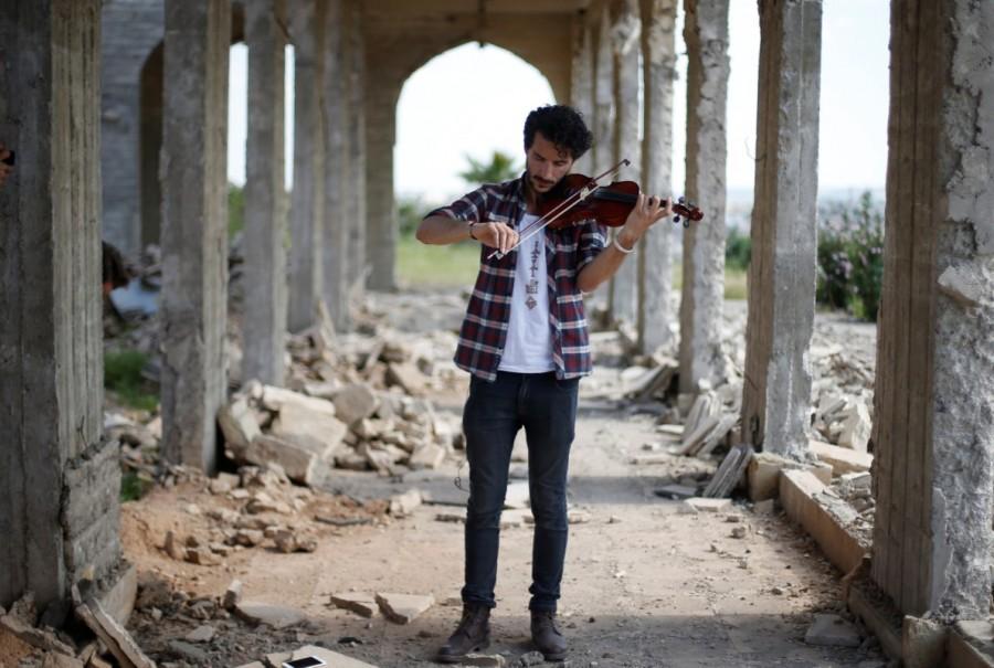 Ameen Mukdad, a violinist from Mosul who lived under ISIS's rule for two and a half years where they destroyed his musical instruments, performs at Nabi Yunus shrine in eastern Mosul, Iraq, April 19, 2017. Iraqi violinist,violinist,Mosul after ISIS,Iraqi violinist returns to play Mosul,Muslims and Christians in Mosul,Ameen Mukdad,Islamic State militants,Islamic State