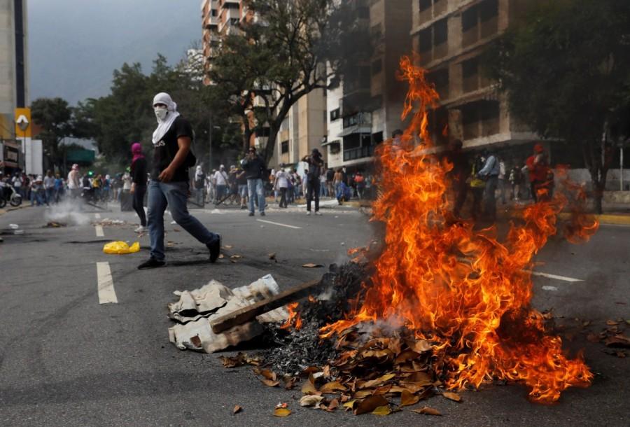 An opposition demonstrator walks while clashing with riot police during the so called "mother of all marches" against Venezuela's President Nicolas Maduro in Caracas, Venezuela, April 19, 2017. Mother of all marches,Venezuela,President Nicolas Maduro,Nicolas Maduro,violent demonstrations,demonstrations