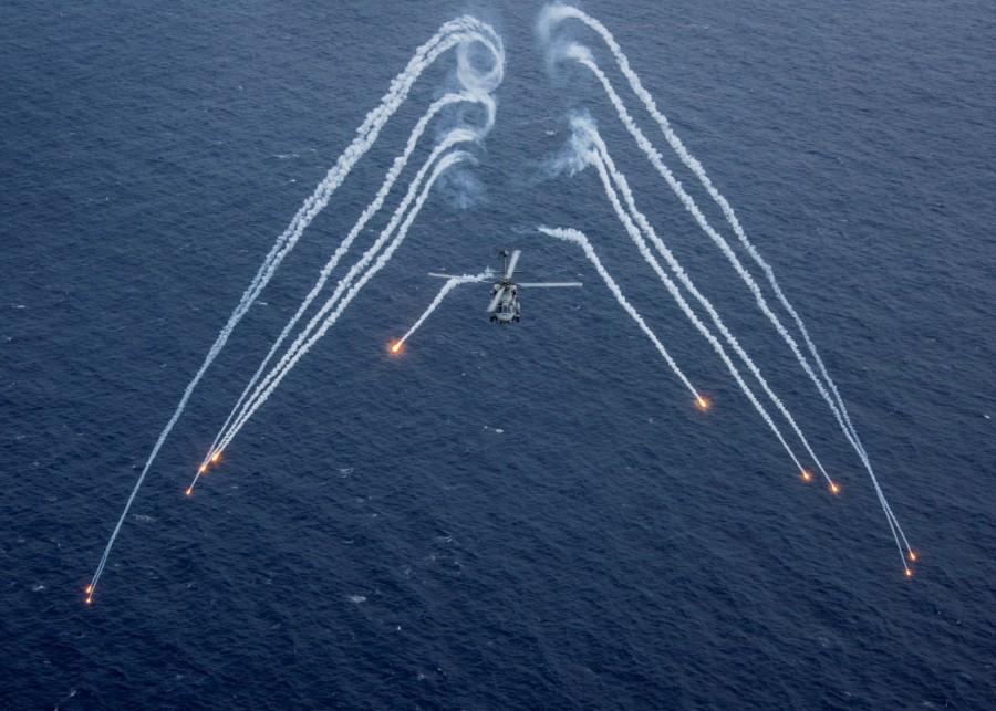 A U.S. Navy MH-60R Sea Hawk helicopter from the "Blue Hawks" of Helicopter Maritime Strike Squadron 78 fires chaff flares during a training exercise near the aircraft carrier USS Carl Vinson (CVN 70) in the Philippine Sea April 24, 2017. In a show of force, the United States is sending the USS Carl Vinson aircraft carrier group to waters off the Korean peninsula, where it will join the USS Michigan, a nuclear submarine that docked in South Korea on Tuesday. South Korea's navy has said it will hold drills with the U.S. strike group. USS Carl Vinson,Carl Vinson,USS Carl Vinson on patrol,USS Carl Vinson aircraft,Korean waters,USS Michigan,North Korean,North Korean nuclear