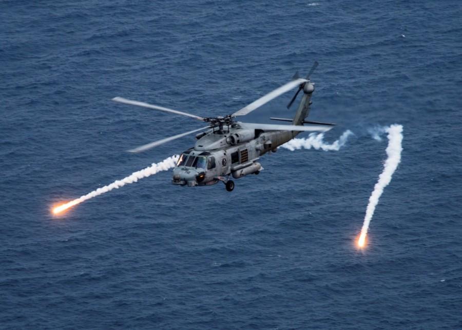 A U.S. Navy MH-60R Sea Hawk helicopter from the "Blue Hawks" of Helicopter Maritime Strike Squadron 78 fires chaff flares during a training exercise near the aircraft carrier USS Carl Vinson (CVN 70) in the Philippine Sea April 24, 2017. North Korea said it was ready to sink the aircraft carrier to demonstrate its military might. "Our revolutionary forces are combat-ready to sink a U.S. nuclear-powered aircraft carrier with a single strike," the Rodong Sinmun, the newspaper of the North's ruling Workers' Party, said in a commentary. The paper likened the aircraft carrier to a "gross animal" and said a strike on it would be "an actual example to show our military's force". USS Carl Vinson,Carl Vinson,USS Carl Vinson on patrol,USS Carl Vinson aircraft,Korean waters,USS Michigan,North Korean,North Korean nuclear