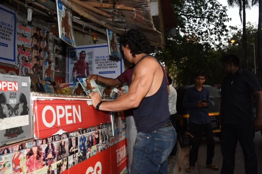 The magazine cover made it's way to the market only yesterday and it seems like Tiger couldn't contain his excitement to grab a copy. Tiger's visit had the magazine vendor stunned, who was seen finding it difficult to absorb the presence of the star on the street. Tiger Shroff,actor Tiger Shroff,Tiger Shroff at local magazine stall