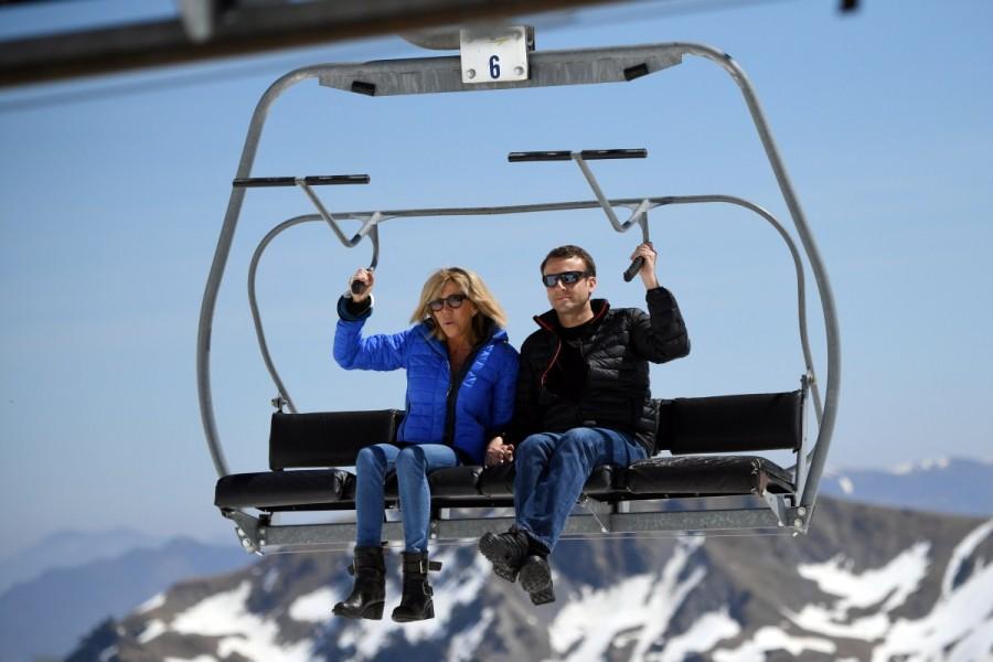 Emmanuel Macron and his wife Brigitte Trogneux sit on a chairlift on their way to the mountain top for a lunch break during a campaign visit in Bagneres de Bigorre, in the Pyrenees mountain. Emmanuel Macron,Meet France's new First Lady,France First Lady,French President-elect Emmanuel Macron,Emmanuel Macron wife