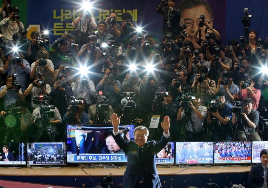 Moon Jae-in gestures to his party members as they watch a television report on a presidential election exit poll in Seoul, South Korea. Moon Jae-in,South Korea elects Moon Jae-in,South Korea's presidential election,North Korea,Liberal politician