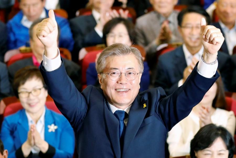 Moon Jae-in poses for photographs as he watches a television report on exit polls. Moon Jae-in,South Korea elects Moon Jae-in,South Korea's presidential election,North Korea,Liberal politician