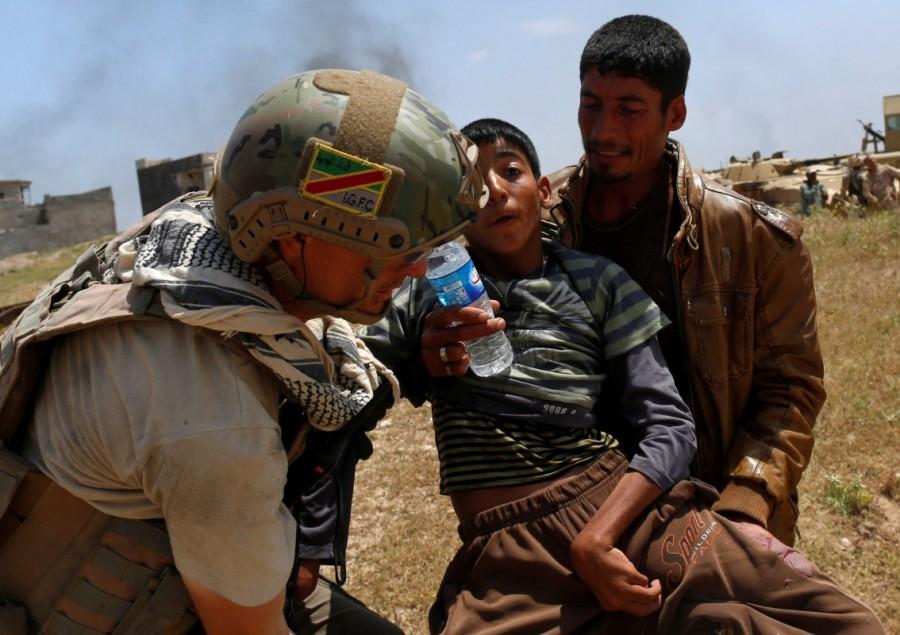 A displaced Iraqi boy is carried as members of the Iraqi Army clash with Islamic State fighters in the north west of Mosul, Iraq, May 5, 2017. Iraqi forces,west Mosul,northwest Mosul