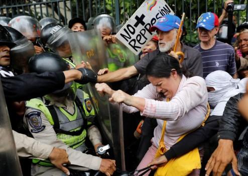 Opposition supporters confront riot security forces while rallying against President Nicolas Maduro in Caracas, Venezuela. Venezuela's elderly have been hard hit by four years of brutal recession, leading to shortages of food and medicines, long lines at shops and runaway prices.