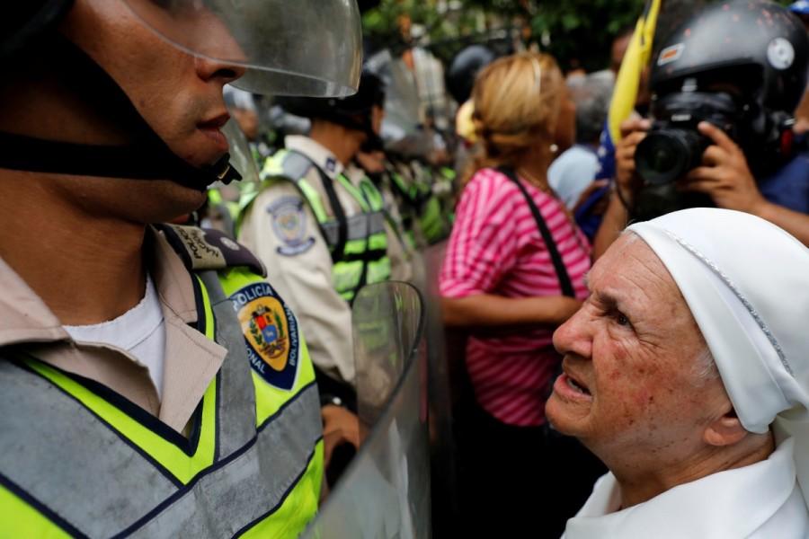 A nun (R) confronts riot security forces while rallying against President Nicolas Maduro in Caracas, Venezuela, May 12, 2017. Elderly Venezuelan protesters threw punches and yelled curses at riot police blocking the latest in six weeks of demonstrations against President Nicolas Maduro's socialist government. Elderly Venezuelan,Elderly Venezuelan protesters,President Nicolas Maduro,Venezuelan President Nicolas Maduro,Nicolas Maduro