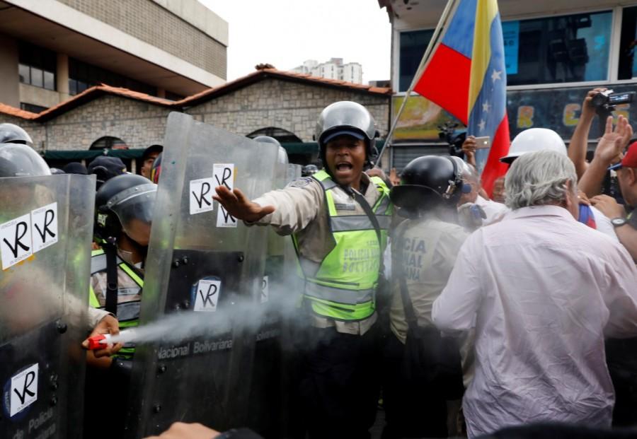 Riot security forces uses a pepper spray as elderly opposition supporters confront them while rallying against President Nicolas Maduro in Caracas. Riot police with helmets and shields used pepper gas several times to control the crowd as hundreds of pensioners jostled against security lines to attempt a march from a Caracas square. Elderly Venezuelan,Elderly Venezuelan protesters,President Nicolas Maduro,Venezuelan President Nicolas Maduro,Nicolas Maduro
