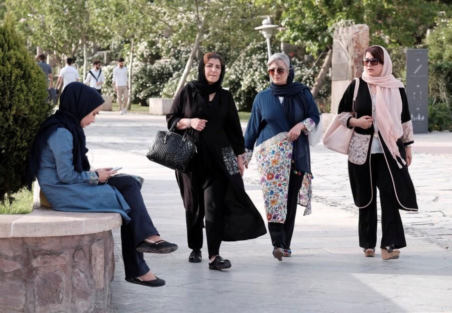 An Iranian woman uses her mobile phone as she rests at a park in Tehran, Iran, May 16, 2017. Many Iranians feel a 2015 agreement Rouhani championed with major powers to lift sanctions in return for curbing Iran's nuclear program has failed to produce the jobs, growth and foreign investment he said would follow. The normally mild-mannered cleric is trying to hold on to office by firing up reformist voters who want less confrontation abroad and more social and economic freedom at home. Iran,Iran presidential election,presidential election,Hardline cleric Ebrahim Raisi,President Hassan Rouhani,Hassan Rouhani