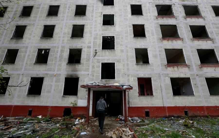 A worker passes a building, which is part of the old five-storey apartment blocks demolition project launched by the city authorities, in Moscow, Russia. The Moscow government plans to resettle millions of citizens from shoddy Soviet-era apartment blocks. The draft law on renovation envisages moving some Muscovites into modern flats but has also fuelled concerns about property rights, a year after city authorities provoked an outcry among small businesses by bulldozing many street kiosks. Moscow government,Soviet-era apartments,Soviet-era apartment blocks,Soviet-era,Nikita Krushchev
