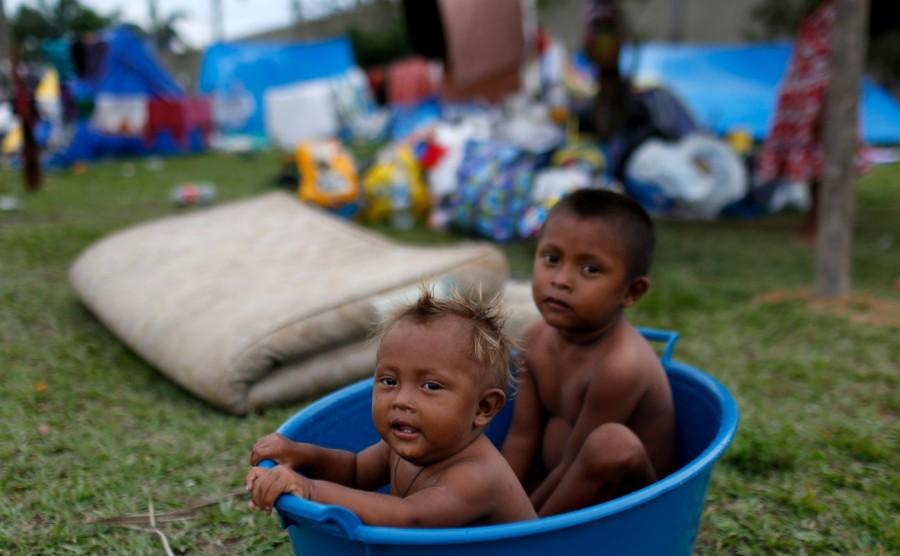 Children from the indigenous Warao people from the Orinoco Delta in eastern Venezuela, are seen in a plastic bucket near a viaduct next to a bus terminal in Manaus, Brazil. Since late last year, then, as many as 355 Warao have made the 1,000 km (620 miles) bus journey from northeastern Venezuela to Manaus, a city of 2 million people where local authorities are now scrambling to help them find shelter, food and medicine. Venezuela,indigenous flee crisis,flee crisis,Caribbean coast,Manaus,Amazonian metropolis