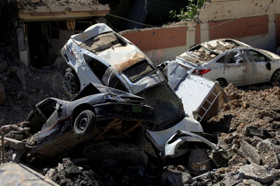 Cars destroyed in clashes are seen on a street during a battle between Iraqi forces and Islamic State militants in western Mosul. Endgame in Mosul,Mosul,Mosul Endgame,recapture Mosul,Islamic State militants,Islamic State