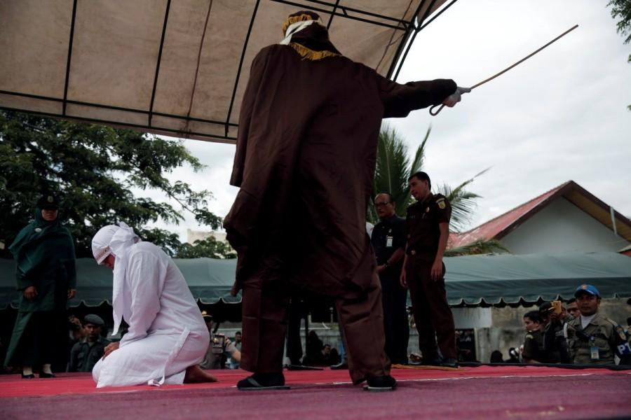 An Indonesian woman is publicly caned for spending time with a man who is not her husband, in Banda Aceh, Aceh province, Indonesia. Gay sex,gay sex in Indonesia,Two men publicly caned,Indonesia for having gay sex,Two men caned 83 times for gay sex,Two men caned 83 times