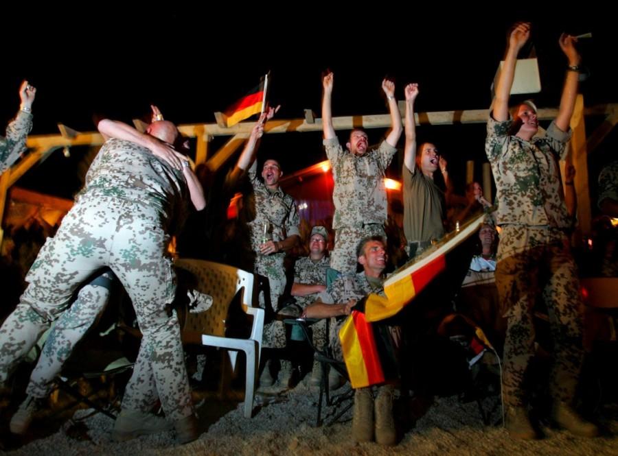German soldiers from the NATO-led international peacekeepers cheer, as they watch Germany score a goal against Costa Rica during the opening soccer match of the World Cup on television, in Kabul June 9, 2006. Treaty Organization,North American Treaty Organization,NATO in the modern world,NATO