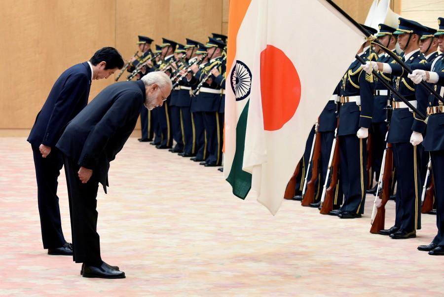 Indian Prime Minister Narendra Modi (2nd L) and his Japanese counterpart Shinzo Abe (L) bow to national flags as they review an honor guard before their meeting at Abe's official residence in Tokyo, Japan November 11, 2016. Narendra Modi,PM Narendra Modi,Modi,PM Modi,3 yrs of Narendra Modi govt,Narendra Modi government turns 3,NaMo,NaMo 3 years