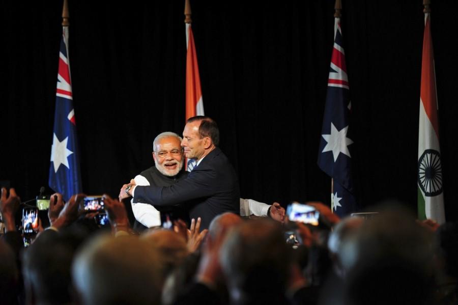 India's Prime Minister Narendra Modi (L) is hugged by Australia's Prime Minister Tony Abbott during a reception at the Melbourne Cricket Ground November 18, 2014. Prime Minister Narendra Modi,Narendra Modi,Narendra Modi hugs,Modi special,3 years of Modi,3 years of Narendra Modi