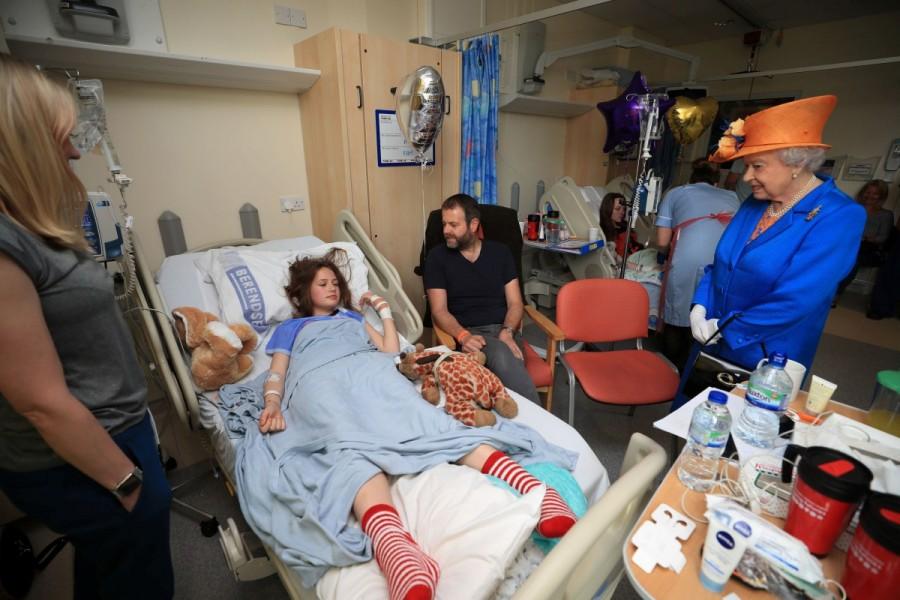 Queen Elizabeth speaks to Evie Mills, 14, from Harrogate, her mother, Karen and dad, Craig. Queen Elizabeth,Elizabeth,Queen Elizabeth visits Manchester bombing casualties,Elizabeth visits Manchester bombing casualties,queen elizabeth visits manchester victims,manchester victims